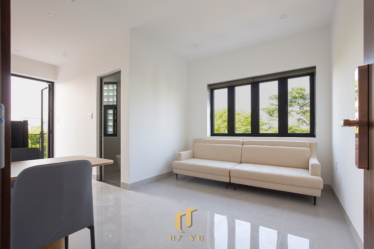 Mỡ Apartment – Căn Hộ Cho Thuê Đà Nẵng Hiện Đại, Tối Ưu 13-Phòng khách căn hộ Mỡ Apartment với sofa sáng màu và cửa sổ lớn đón ánh sáng tự nhiên