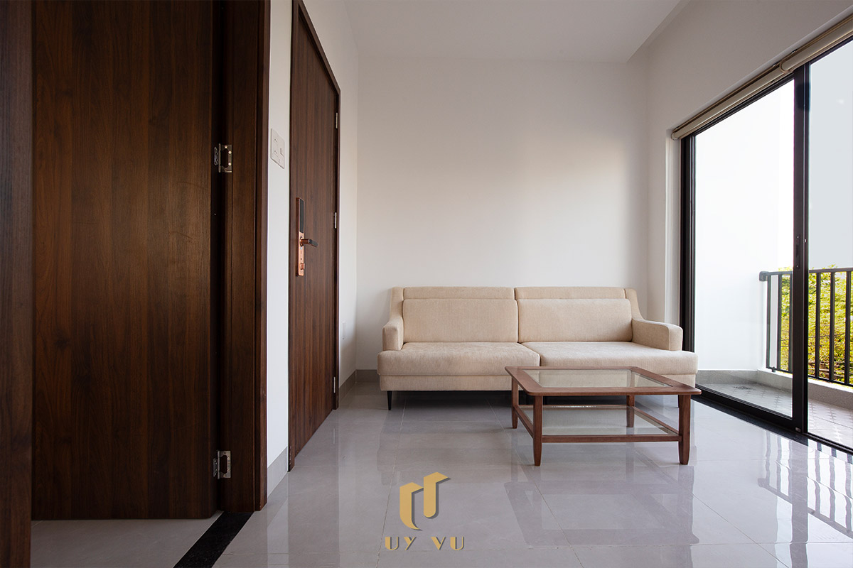 Mỡ Apartment – Căn Hộ Cho Thuê Đà Nẵng Hiện Đại, Tối Ưu 39 - Phòng khách căn hộ cho thuê Đà Nẵng có sofa, bàn trà và ban công thoáng mát